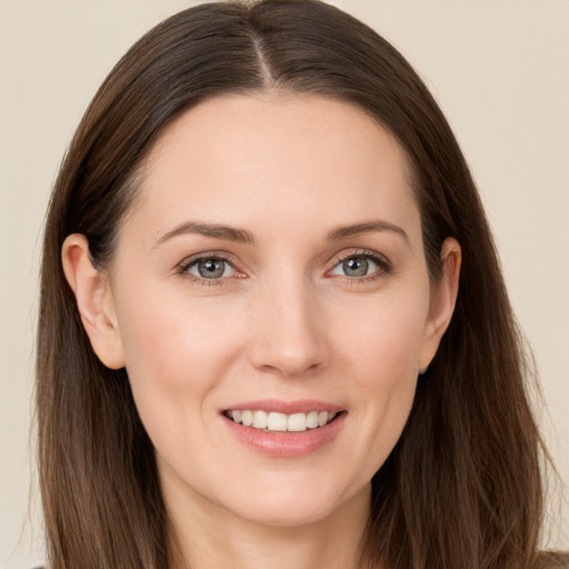 Joyful white young-adult female with long  brown hair and grey eyes