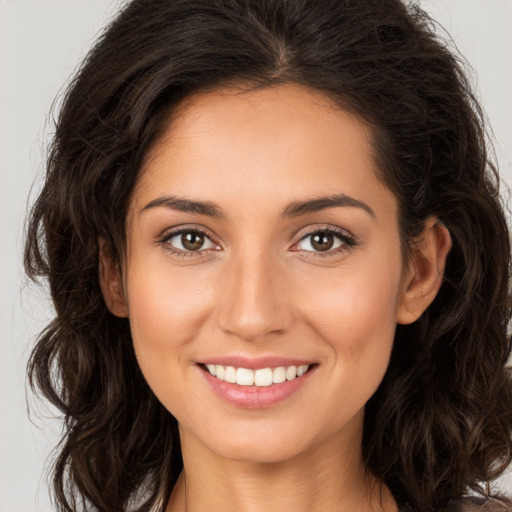 Joyful white young-adult female with long  brown hair and brown eyes