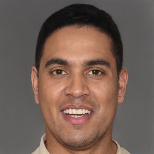 Joyful latino young-adult male with short  black hair and brown eyes