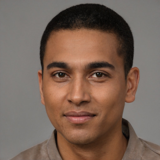 Joyful black young-adult male with short  black hair and brown eyes