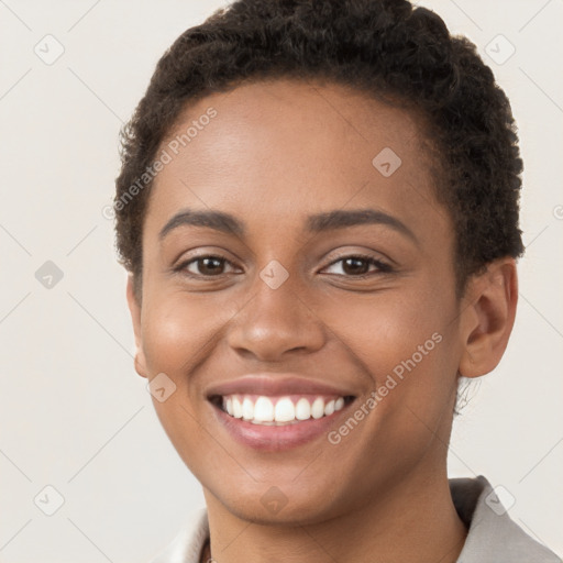 Joyful black young-adult female with short  brown hair and brown eyes