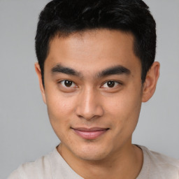 Joyful asian young-adult male with short  black hair and brown eyes