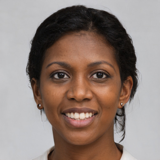 Joyful black young-adult female with medium  black hair and brown eyes
