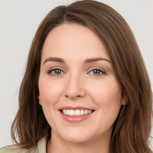 Joyful white young-adult female with long  brown hair and green eyes