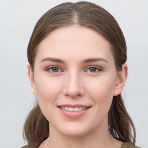 Joyful white young-adult female with long  brown hair and grey eyes