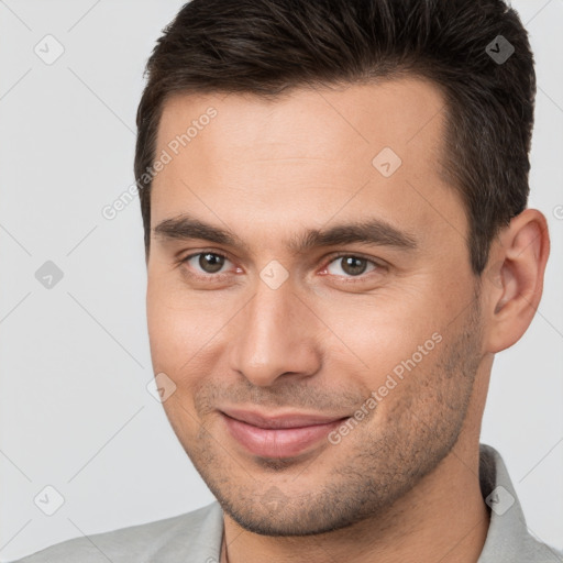 Joyful white young-adult male with short  brown hair and brown eyes