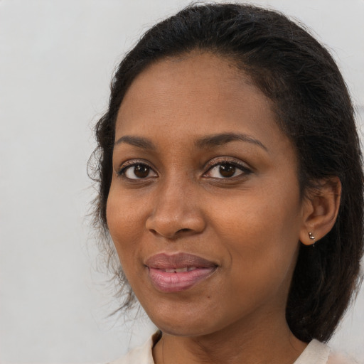 Joyful black young-adult female with medium  brown hair and brown eyes
