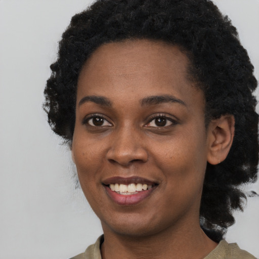 Joyful black young-adult female with short  black hair and brown eyes