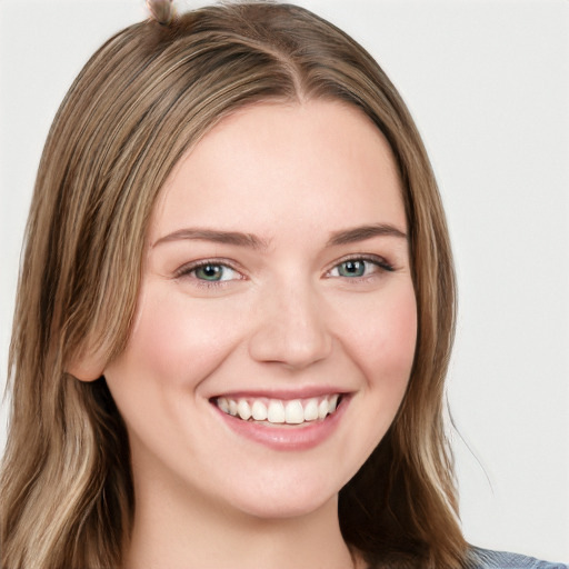 Joyful white young-adult female with long  brown hair and blue eyes