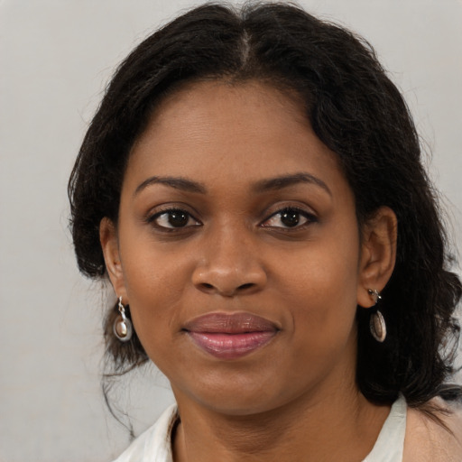 Joyful black young-adult female with medium  brown hair and brown eyes