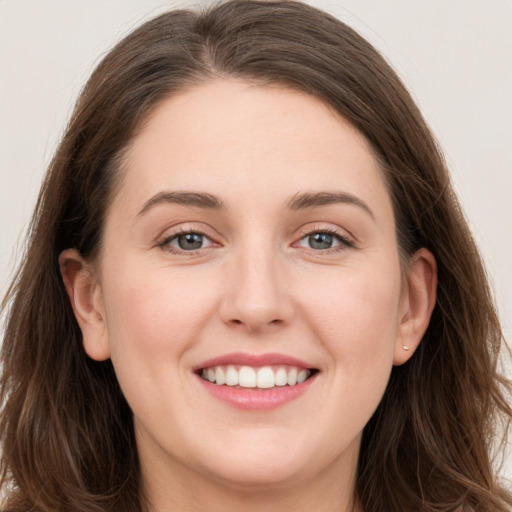 Joyful white young-adult female with long  brown hair and grey eyes