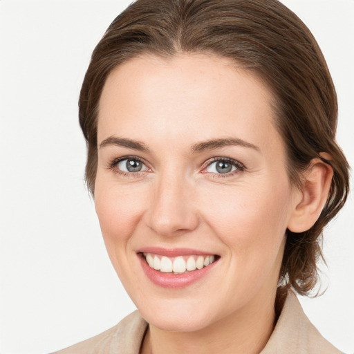 Joyful white young-adult female with medium  brown hair and grey eyes