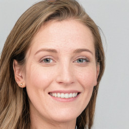 Joyful white young-adult female with long  brown hair and blue eyes