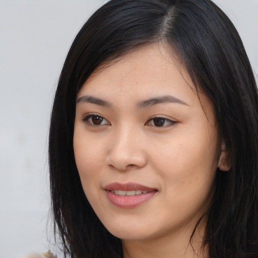 Joyful asian young-adult female with long  black hair and brown eyes
