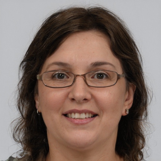 Joyful white adult female with long  brown hair and green eyes