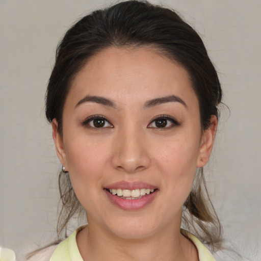 Joyful latino young-adult female with medium  brown hair and brown eyes