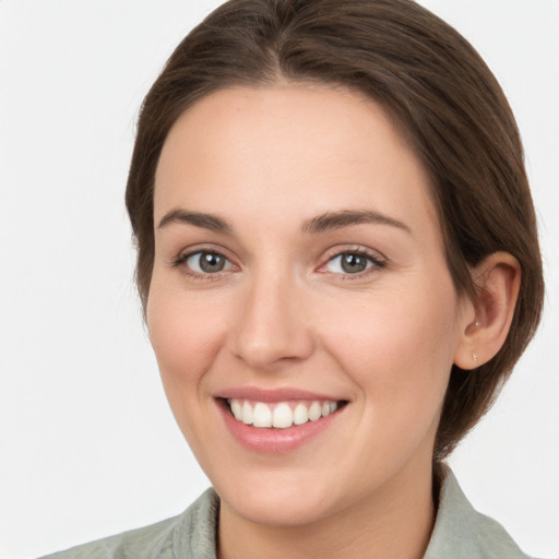 Joyful white young-adult female with medium  brown hair and grey eyes