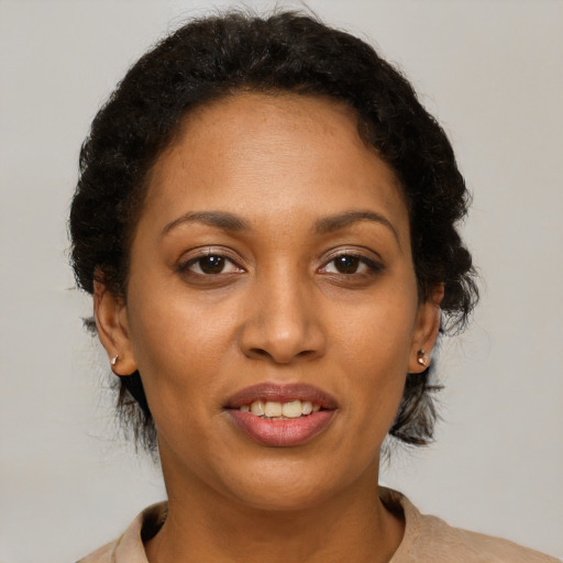 Joyful black young-adult female with short  brown hair and brown eyes