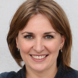 Joyful white adult female with medium  brown hair and grey eyes