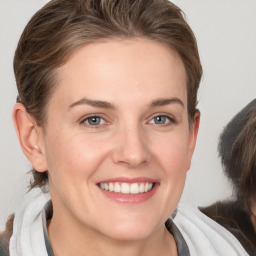 Joyful white young-adult female with medium  brown hair and grey eyes