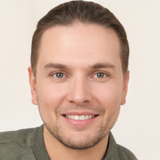 Joyful white young-adult male with short  brown hair and grey eyes