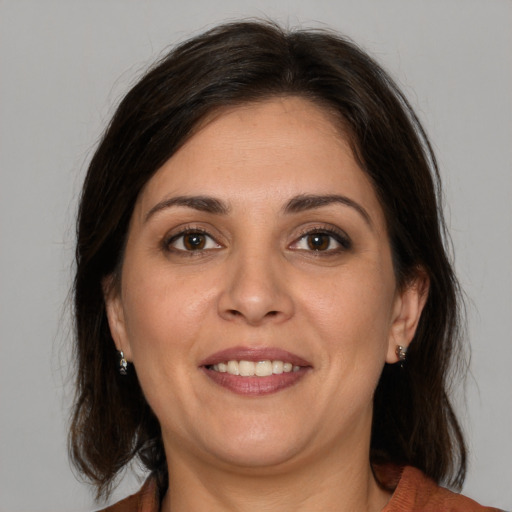 Joyful white adult female with medium  brown hair and brown eyes