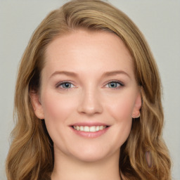 Joyful white young-adult female with long  brown hair and blue eyes