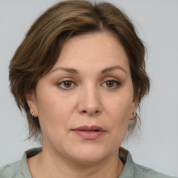 Joyful white adult female with medium  brown hair and grey eyes