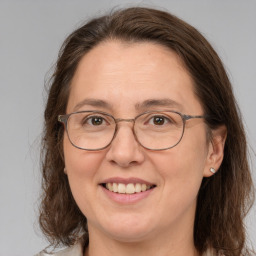 Joyful white adult female with medium  brown hair and grey eyes