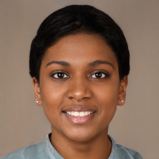 Joyful black young-adult female with short  black hair and brown eyes
