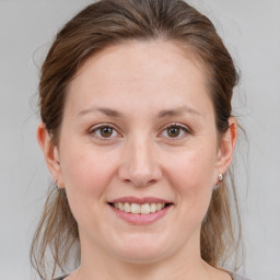 Joyful white young-adult female with medium  brown hair and grey eyes