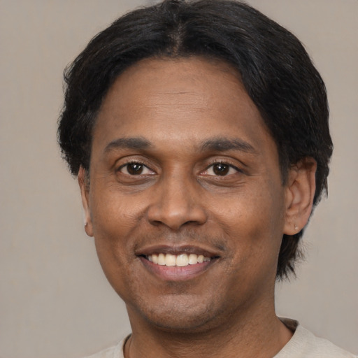Joyful black adult male with short  black hair and brown eyes