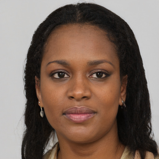 Joyful black young-adult female with long  brown hair and brown eyes