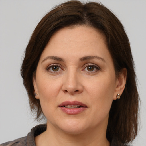 Joyful white adult female with medium  brown hair and brown eyes