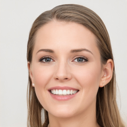 Joyful white young-adult female with long  brown hair and blue eyes