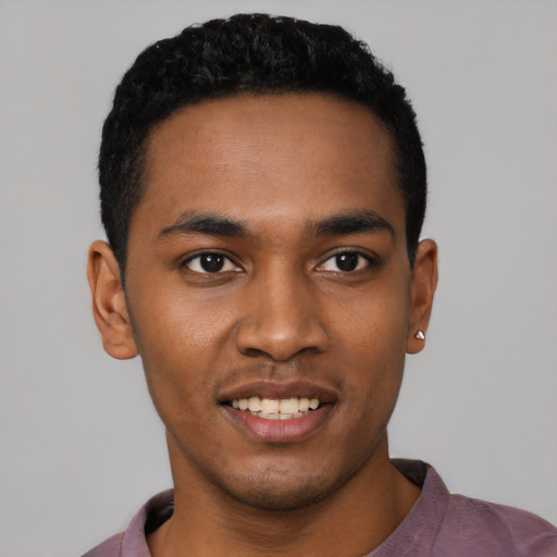 Joyful black young-adult male with short  black hair and brown eyes
