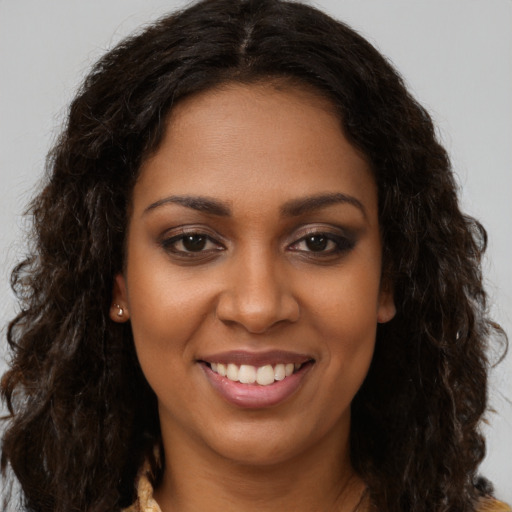 Joyful black young-adult female with long  brown hair and brown eyes