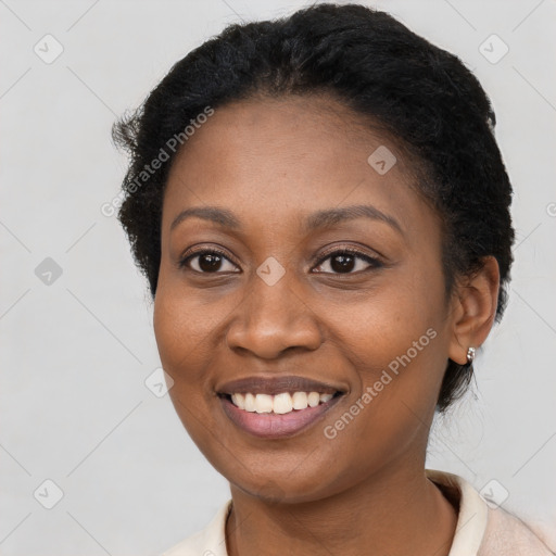 Joyful black young-adult female with short  brown hair and brown eyes