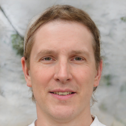 Joyful white adult male with short  brown hair and blue eyes