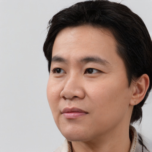 Joyful asian young-adult male with short  black hair and brown eyes