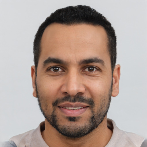 Joyful latino young-adult male with short  black hair and brown eyes