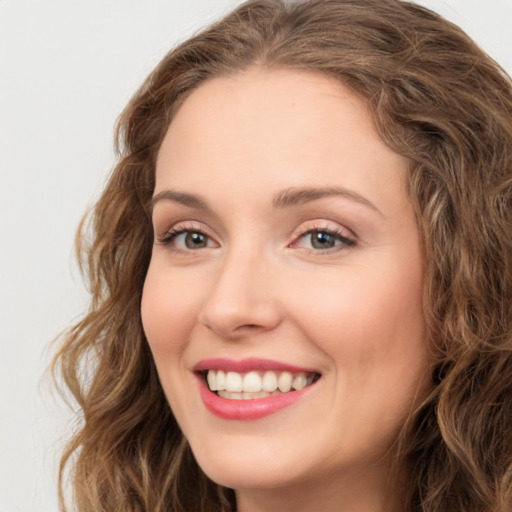 Joyful white young-adult female with long  brown hair and green eyes