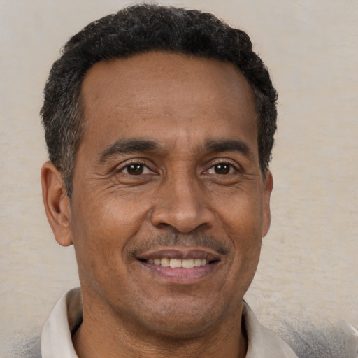 Joyful black adult male with short  brown hair and brown eyes