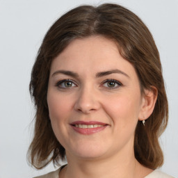 Joyful white young-adult female with medium  brown hair and green eyes