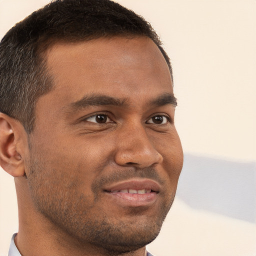 Joyful black young-adult male with short  brown hair and brown eyes