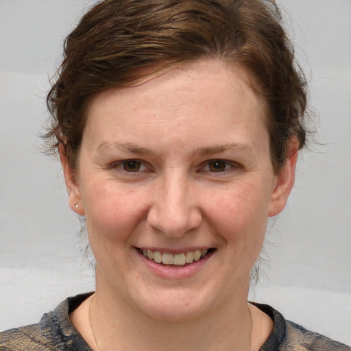 Joyful white young-adult female with medium  brown hair and blue eyes