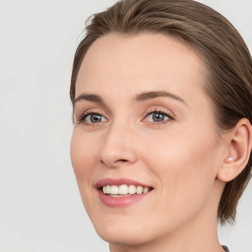 Joyful white young-adult female with medium  brown hair and blue eyes