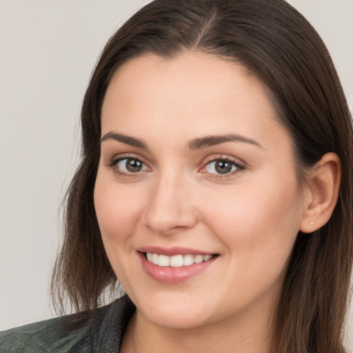 Joyful white young-adult female with long  brown hair and brown eyes