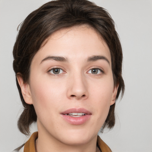 Joyful white young-adult female with medium  brown hair and grey eyes