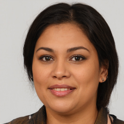 Joyful latino young-adult female with medium  brown hair and brown eyes